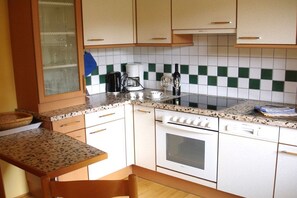 A kitchen with white cabinets, a granite countertop, a stove, and a window with a view. - 1 in the romantic guesthouse Annas-Home (Ratsch)