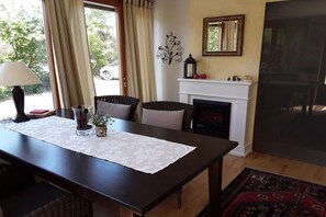A dining area with a table, chairs, a fireplace, and a view of the outside. - 1 in the romantic guesthouse Annas-Home (Ratsch)
