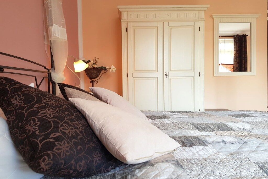 Ein Schlafzimmer mit einem Bett, einem Kleiderschrank und einem Nachttisch mit einer Lampe.