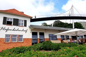 Un edificio con un cartel que dice 'Hafenbahnhof' y un puente peatonal encima.