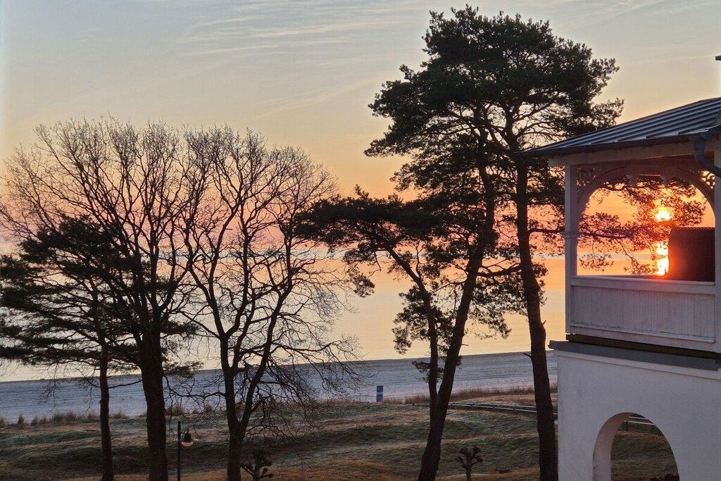 Ein Pavillon mit Blick auf den Sonnenuntergang über dem Wasser.