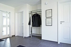 A hallway with a coat rack, two framed pictures on the wall, and a door on the right. - The Seibert Baltic Sea House (Graal-Müritz)