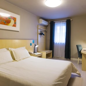 A hotel room with a bed, bedside table, lamp, air conditioning unit, and a desk with a chair. - Jinjiang Inn Select Shenzhen Nanshan Science and Technology Park (Shenzhen)