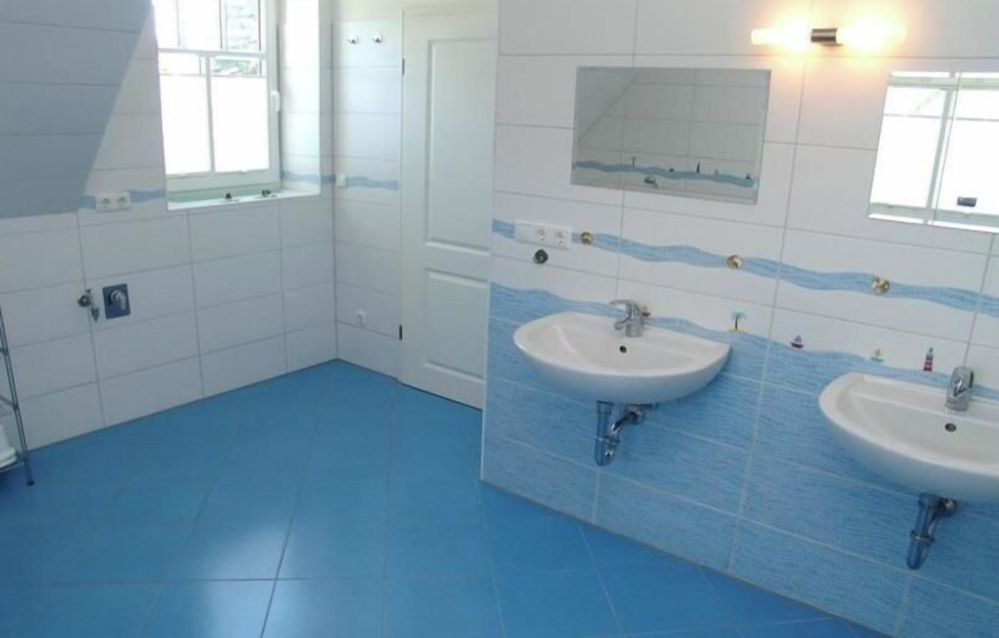 A bathroom with two sinks, a mirror, and a window.