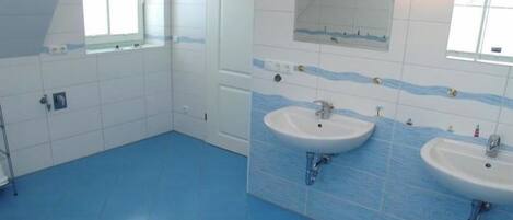 A bathroom with two sinks, a mirror, and a window.
