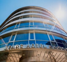 A modern hotel with a curved facade and large windows.
