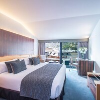 Una habitación de hotel con una cama grande, un escritorio y vistas a la ciudad.