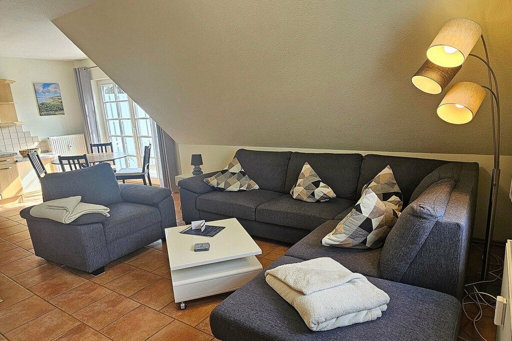 A living room with a sofa set, a coffee table, and a lamp.