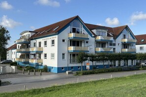 Ein mehrstöckiges Hotel mit einer blau-weißen Fassade, Balkonen und blauem Himmel.