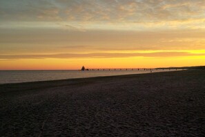 A beach with a pier extending into the water during sunset. - Holiday apartment with 3 bedrooms (Zinnowitz)