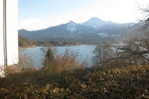Un paysage montagneux avec un lac et des sommets enneigés en arrière-plan.