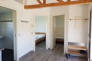 Ein Schlafzimmer mit einem Bett, einer hölzernen Bank und einem Schuhregal.