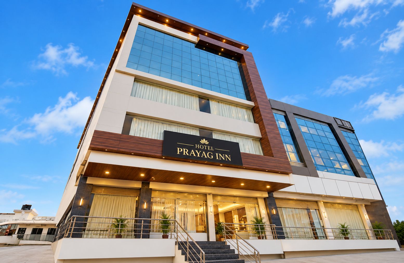 Un hotel de varios pisos con un letrero destacado que dice 'Hotel Prayag Inn'.