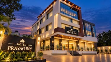 A multi-story hotel with a prominent entrance, a signboard, and a well-lit facade.