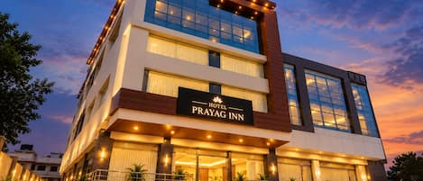 A multi-story hotel with a prominent sign reading 'PRAYAG INN HOTEL'.