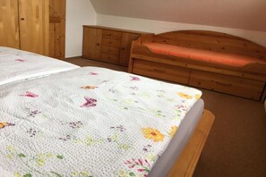 A bedroom with a bed, wooden dresser, and a wooden headboard. - Holiday home in Kägsdorf with swimming pool (Kägsdorf)