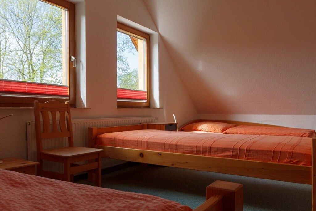 Une chambre avec un lit simple, une chaise et une fenêtre.