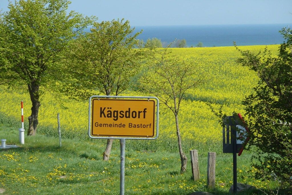 Un paysage rural avec un panneau jaune indiquant « Kägsdorf, commune de Bastianf. »