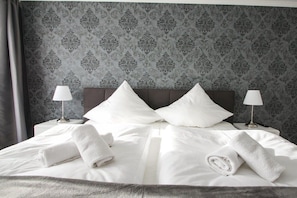 A neatly made bed with white linens, two pillows, and rolled towels. - Villa Louisa 40 - Lighthouse (Ostseebad Sellin)