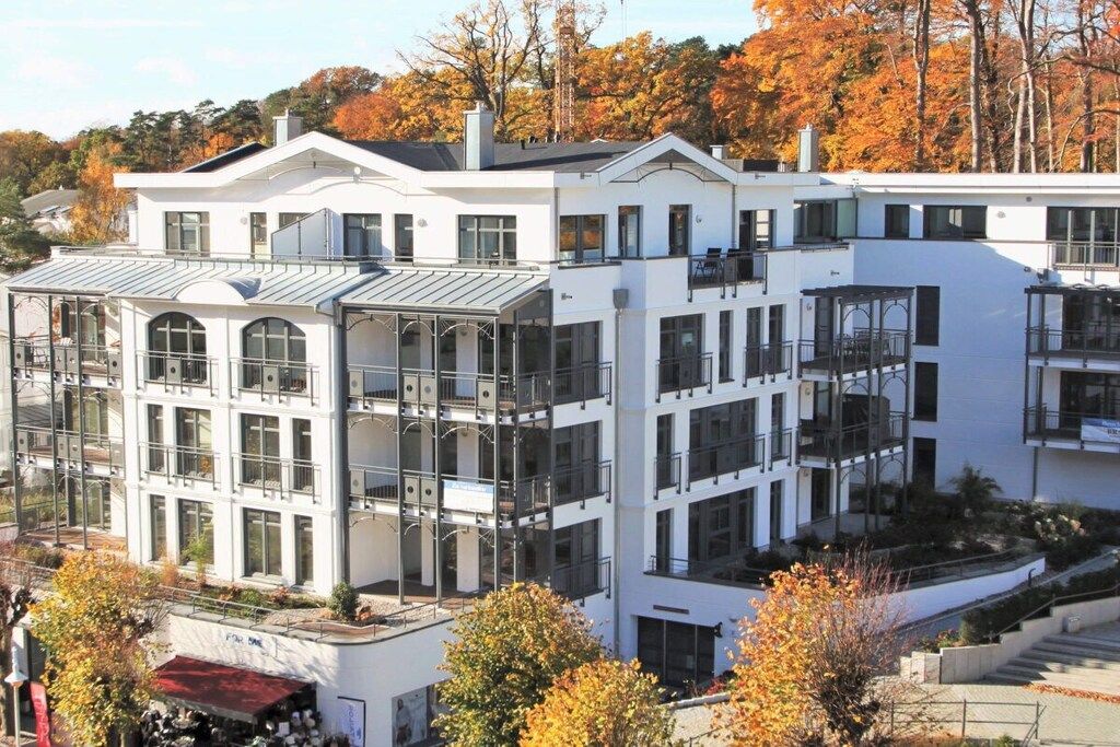 Ein mehrstöckiges Gebäude mit Balkonen, großen Fenstern und einem Flachdach.