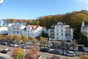 A hotel with multiple white buildings, a parking lot, and trees in the background. - Villa Louisa 48 - Prince Malte (Ostseebad Sellin)