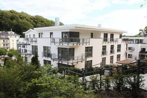 A multi-story residential building with balconies, large windows, and a flat roof. - Villa Louisa 48 - Prince Malte (Ostseebad Sellin)