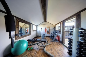 A gym with exercise equipment, a bench, and a mirror. - The Factory (Hapuku)