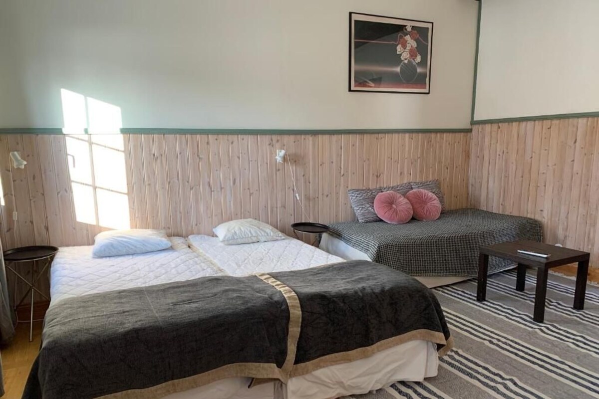A room with two beds, a small table, and a chair.