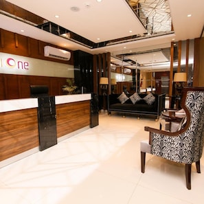 A reception area with a reception desk, a sofa, and a patterned armchair.