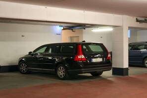 Eine Parkgarage mit einem schwarzen SUV, das in einem dafür vorgesehenen Stellplatz geparkt ist.