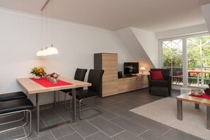 Ein modernes Wohnzimmer mit Essbereich, Fernseher und Kamin.