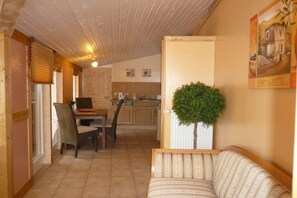 A cozy living room with a sofa and a dining area with a table and chairs. - "TUSCANY" with balcony and 2 bedrooms (Waren)