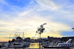 A marina with boats docked, a clear sky, and buildings in the background. - "TUSCANY" with balcony and 2 bedrooms (Waren)