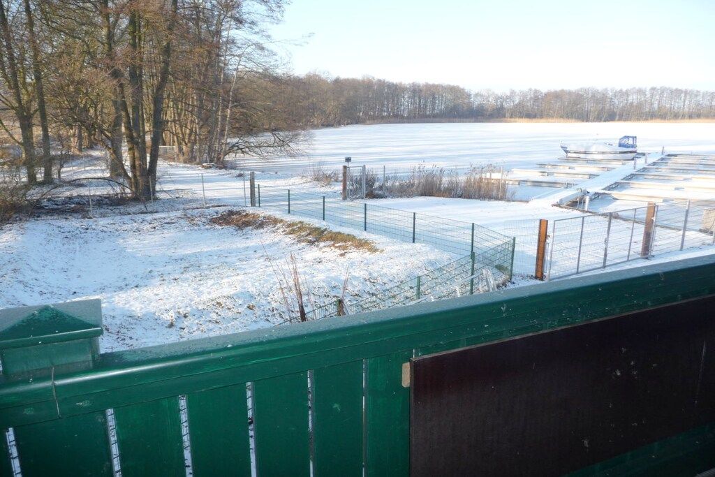 Campo nevado con un área cercada y un muelle para barcos.
