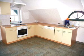 A kitchen with a built-in oven, dishwasher, and a window with a curved view. - Holiday home with 1 bedroom (Alt-Schwerin)