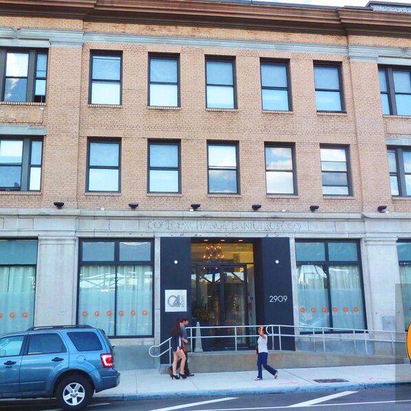 A building with a brick facade, large windows, and a sign indicating a hotel.