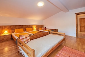 A bedroom with two wooden beds, a nightstand with a lamp, and a wooden wardrobe. - Holiday apartment in Filzmois with barbecue (Filzmoos)