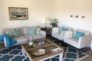 A living room with two sofas, a coffee table, a lamp, and a painting on the wall. - Beach villa "Meerlust" (Ostseebad Dierhagen Strand)