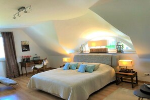 A bedroom with a large bed, two bedside tables, a desk, and a chair. - Beach villa "Meerlust" (Ostseebad Dierhagen Strand)