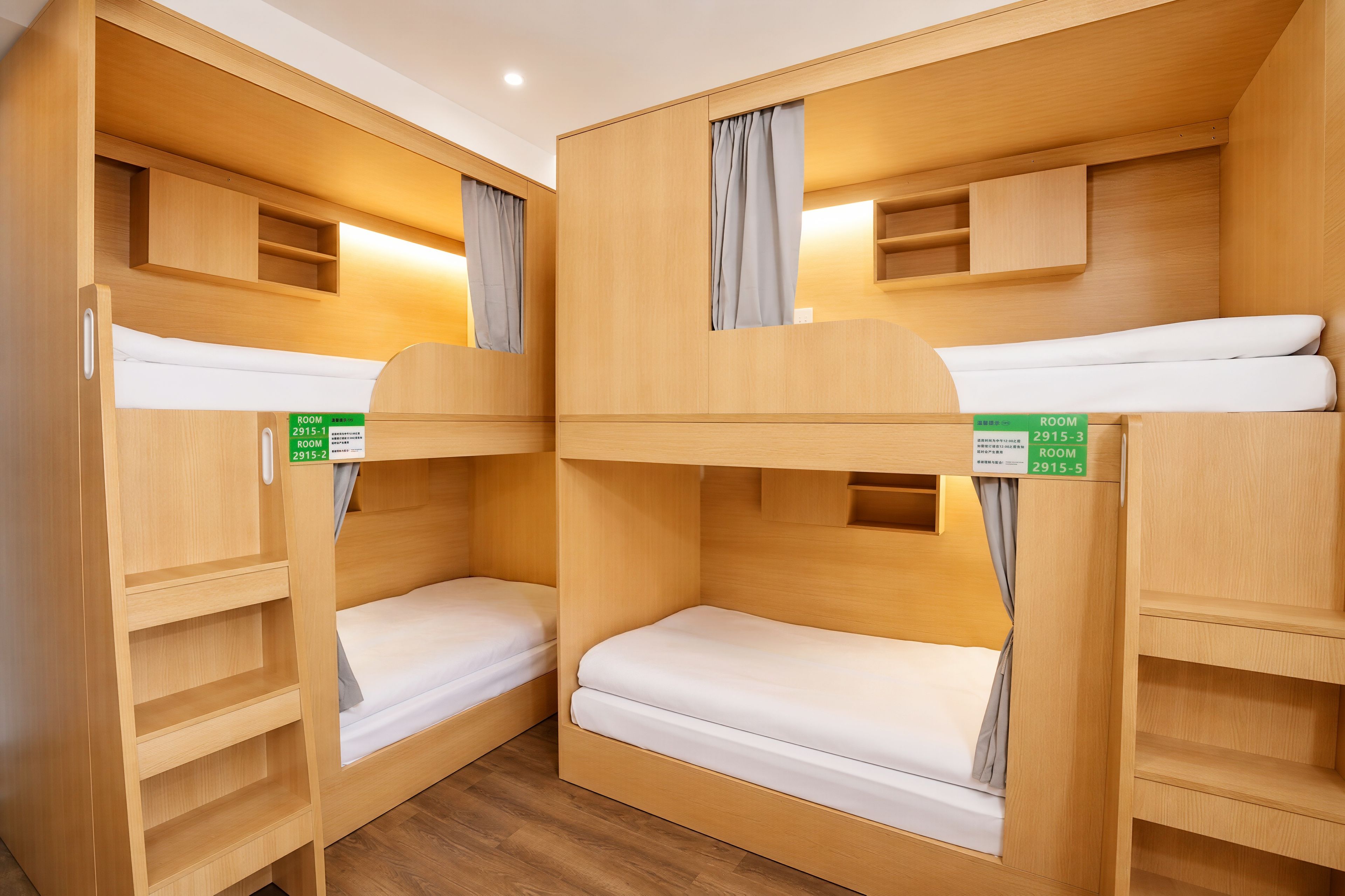 Ein Schlafraum mit Etagenbetten, Holzwänden und einem Schild, das Zimmer 2915-1 ausweist.