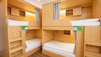 Ein Schlafraum mit Etagenbetten, Holzwänden und einem Schild, das Zimmer 2915-1 ausweist.