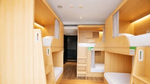 Un interior compacto y bien iluminado con literas y una zona de kitchenette.