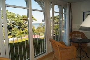 A balcony with a view of the sea, wicker chairs, and a table. - Villa Freia Apt. 20 Granitz (Ostseebad Binz)