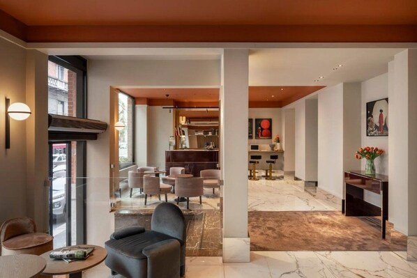 Eine moderne Hotelhalle mit Marmorboden, Sitzgelegenheiten und einer Rezeption.