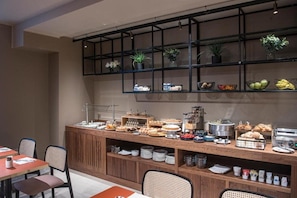 A buffet area with various food items and a wooden counter. - Hotel Del Corso (Milan)