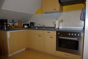 A kitchen with a stove, oven, sink, and various appliances. - Holiday apartment with 1 bedroom (Märkische Heide)