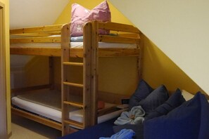 A bunk bed with a ladder, pillows, and a small table with a device. - Holiday apartment with 1 bedroom (Märkische Heide)