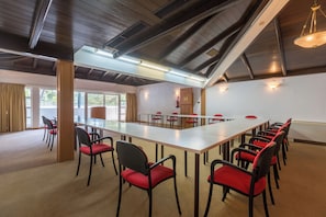 A conference room with a long table, red chairs, and a high ceiling with exposed beams. - Apartments Laguna Galijot (Porec)