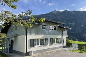 A two-story building with a balcony, large windows, and a mountain backdrop. - Country House Glockner Dream (Heiligenblut am Großglockner)