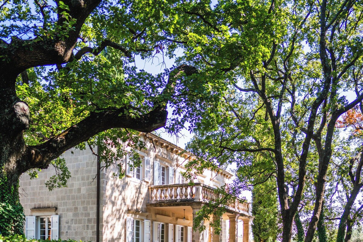 A stone pathway leading to a building with a balcony.